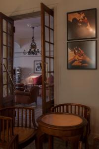 a living room with a table and some chairs at Grand Hôtel Nord-Pinus in Arles