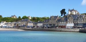 a group of buildings on a beach next to the water at Port de La Houle - Beau 2 pièces classé 3 étoiles avec stationnement in Cancale