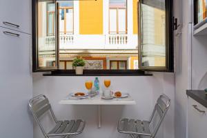 a table and chairs in a room with a window at Luxury apartment in the heart of Genoa by Wonderful Italy in Genoa