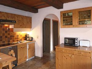 una cucina con armadi in legno e bancone con forno a microonde di Holiday Home Luna by Interhome a Imst