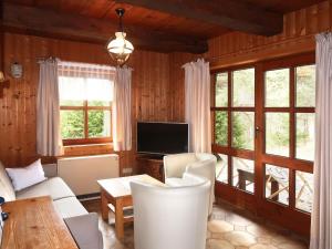 un soggiorno con divano, TV e finestre di Holiday Home Luna by Interhome a Imst