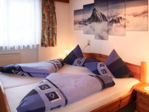 two twin beds in a bedroom with mountains on the wall at Apartment Daheim – Bergliebe by Interhome in Plangeross