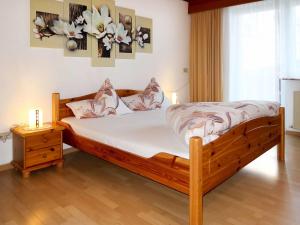 - une chambre avec un lit en bois, deux lampes et une fenêtre dans l'établissement Apartment Daheim – Bergliebe - PZT381 by Interhome, à Plangeross