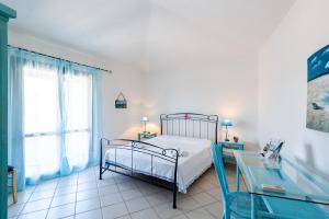 1 dormitorio con cama y mesa de cristal en Villa Barbara - Near Chia Beach, en Domus de Maria