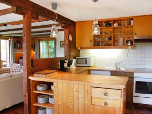 eine Küche mit Holzschränken und einer Arbeitsplatte in der Unterkunft Chalet Les Etoiles by Interhome in Nendaz