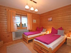 Un dormitorio con 2 camas y una ventana con sábanas moradas. en Apartment Arlberg by Interhome, en Sankt Anton am Arlberg