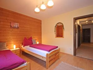 ザンクト・アントン・アム・アールベルクにあるApartment Arlberg by Interhomeのベッドルーム(紫のシーツを使用したベッド2台付)