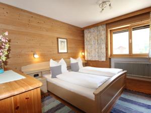 ザンクト・アントン・アム・アールベルクにあるApartment Arlberg by Interhomeの木製の壁のベッドルーム1室(ベッド1台付)