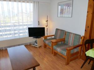 uma sala de estar com duas cadeiras e uma televisão em Apartment Christiania 2 O3 by Interhome em Nendaz