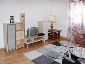 Una sala de estar con un televisor y una mesa. en Apartment Altes Zollhaus-2 by Interhome, en Nauders