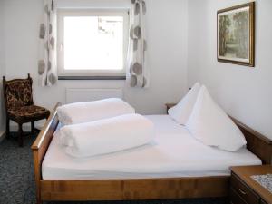 Un dormitorio con una cama con sábanas blancas y una ventana. en Apartment Altes Zollhaus-2 by Interhome, en Nauders 15 fotos más