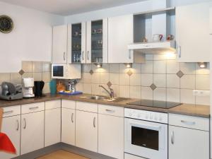 una cocina con armarios blancos y fregadero en Apartment Bergkristall - SIX115 by Interhome, en Spiss