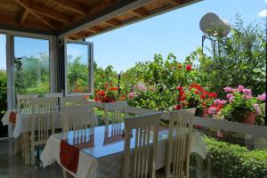 un patio con mesa, sillas y flores en Aleksander ApartHotel, en Ksamil