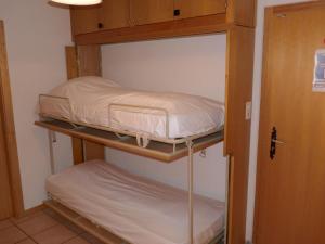 two bunk beds in a room with a door at Apartment Christiania 2 C8 by Interhome in Nendaz
