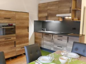 a kitchen with a table and chairs and a kitchen with wooden cabinets at Apartment Rosablanche D31 by Interhome in Siviez +14 photos