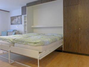1 dormitorio con 1 cama y armario de madera en Apartment Imperial-1 by Interhome, en Zermatt
