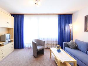 sala de estar con sofá azul y mesa en Apartment Imperial-4 by Interhome, en Zermatt