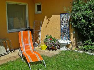 コイチャッハ・アム・ゼーにあるApartment Keutschach by Interhomeの家の隣の芝生に座るオレンジの椅子