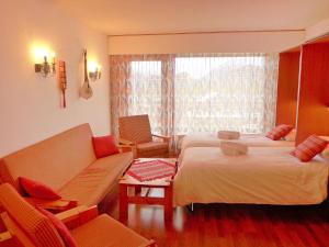 Habitación de hotel con 2 camas y sofá en Apartment Christiania 2 Tbel by Interhome en Nendaz