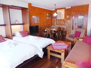 1 dormitorio con 2 camas, mesa y sillas en Apartment Christiania 2 Tbel by Interhome en Nendaz