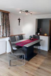 a dining room with a table and a cross on the wall at Apartment Zipparashof - KPL330 by Interhome in Perpat