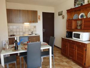 a kitchen with a table with chairs and a microwave at Apartment Gruissan Port-2 by Interhome in Gruissan