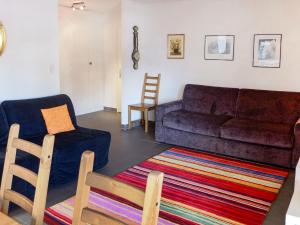 a living room with a couch and a chair at Apartment Zanfleuron A1 by Interhome in Nendaz