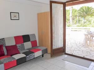 Una sala de estar con un sofá y una puerta corrediza de vidrio. en Holiday Home Les Maisons du Rivage Bleu by Interhome, en Narbonne-Plage 21 fotos más