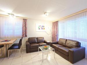ein Wohnzimmer mit einem Sofa und einem Tisch in der Unterkunft Apartment Roger-2 by Interhome in Zermatt
