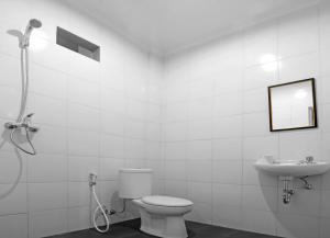 een witte badkamer met een toilet en een wastafel bij Amerta Home Stay Bali in Denpasar +7 foto's