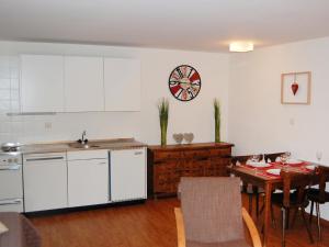 una cucina con tavolo e orologio sul muro di Apartment Quille du Diable 33 by Interhome a Nendaz