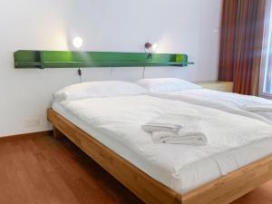 ein großes Bett mit weißer Bettwäsche und einem grünen Kopfteil in der Unterkunft Apartment Gamma by Interhome in Zermatt