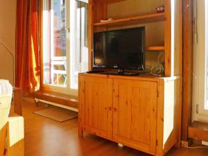 ツェルマットにあるアパートメント ガンマ ツェルマットのリビングルームの木製キャビネットのテレビ