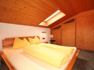 a bedroom with a large bed with yellow sheets at Apartment Krismer by Interhome in Pians