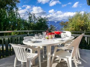 a white table with white chairs on a balcony at Chalet Sven Heul by Interhome in Nendaz