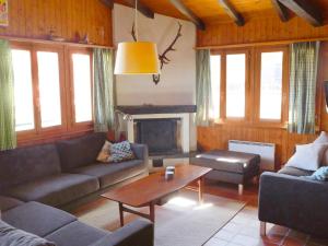 een woonkamer met banken, een tafel en een open haard bij Chalet Sven Heul by Interhome in Nendaz