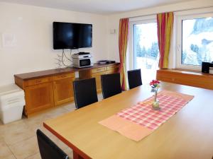 a dining room with a table with chairs and a television at Apartment Apart Sonja by Interhome in Kappl