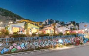 a row of houses and a wall with graffiti at Soulmate Pension in Namhae