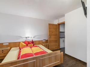 een slaapkamer met een bed met rode en gele kussens bij Apartment Christoph - KPL370 by Interhome in Kappl