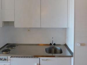 eine Küche mit einem Waschbecken und weißen Schränken in der Unterkunft Apartment Valaisia 35A by Interhome in Nendaz