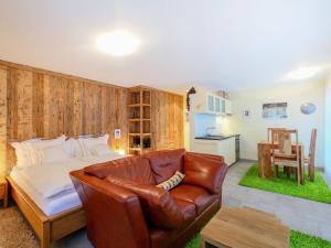 uma sala de estar com um sofá de couro e uma cozinha em Apartment Rütschi-2 by Interhome em Zermatt
