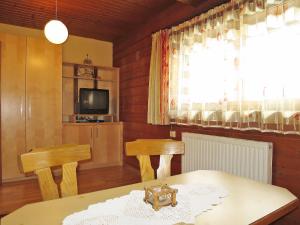 ein Wohnzimmer mit einem Tisch, 2 Stühlen und einem TV in der Unterkunft Holiday Home Hexenhäusl - KAB115 by Interhome in Kaltenbach