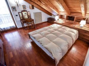 a large bed in a room with a wooden ceiling at Chalet Cesa Galadriel-1 by Interhome in Penia