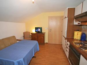 eine kleine Küche mit einem blauen Bett in einem Zimmer in der Unterkunft Apartment Sonnenheim-2 by Interhome in Mayrhofen