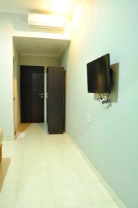 een hal met een flatscreen-tv aan de muur bij Amerta Home Stay Bali in Denpasar