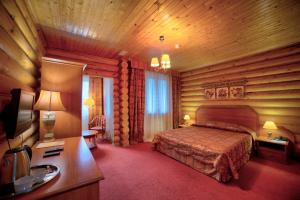 Shaldovo的住宿－Hotel Semigorie，卧室配有一张床铺,位于带木墙的房间内