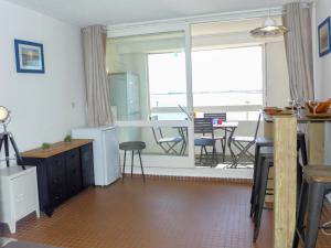 een woonkamer met een keuken en een groot raam bij Apartment Les Occitanes by Interhome in Gruissan