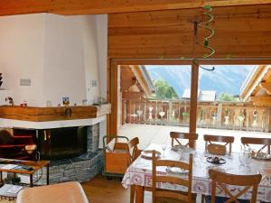 a living room with a fireplace and a table and chairs at Apartment Terrasse du Paradis 7B by Interhome in Nendaz