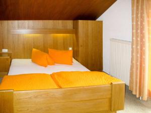 a bedroom with a wooden bed with orange pillows at Apartment Alpenblick - SOE750 by Interhome in Sölden