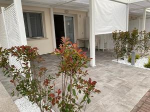 eine Terrasse mit einigen Pflanzen und ein Gebäude in der Unterkunft NEW Apartment Diana Ovest in Bibione